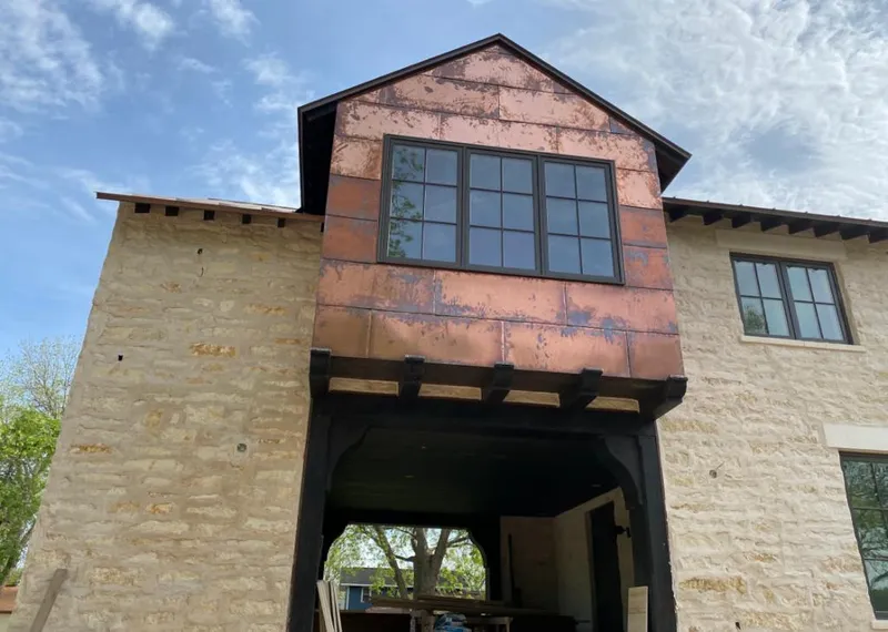 Copper metal panel facade on a stone building for Roof Repair in Daleville