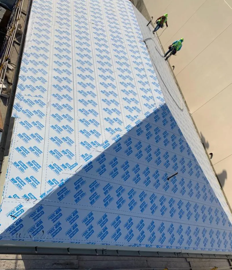 Professional roofers installing underlayment on a metal roof in Daleville